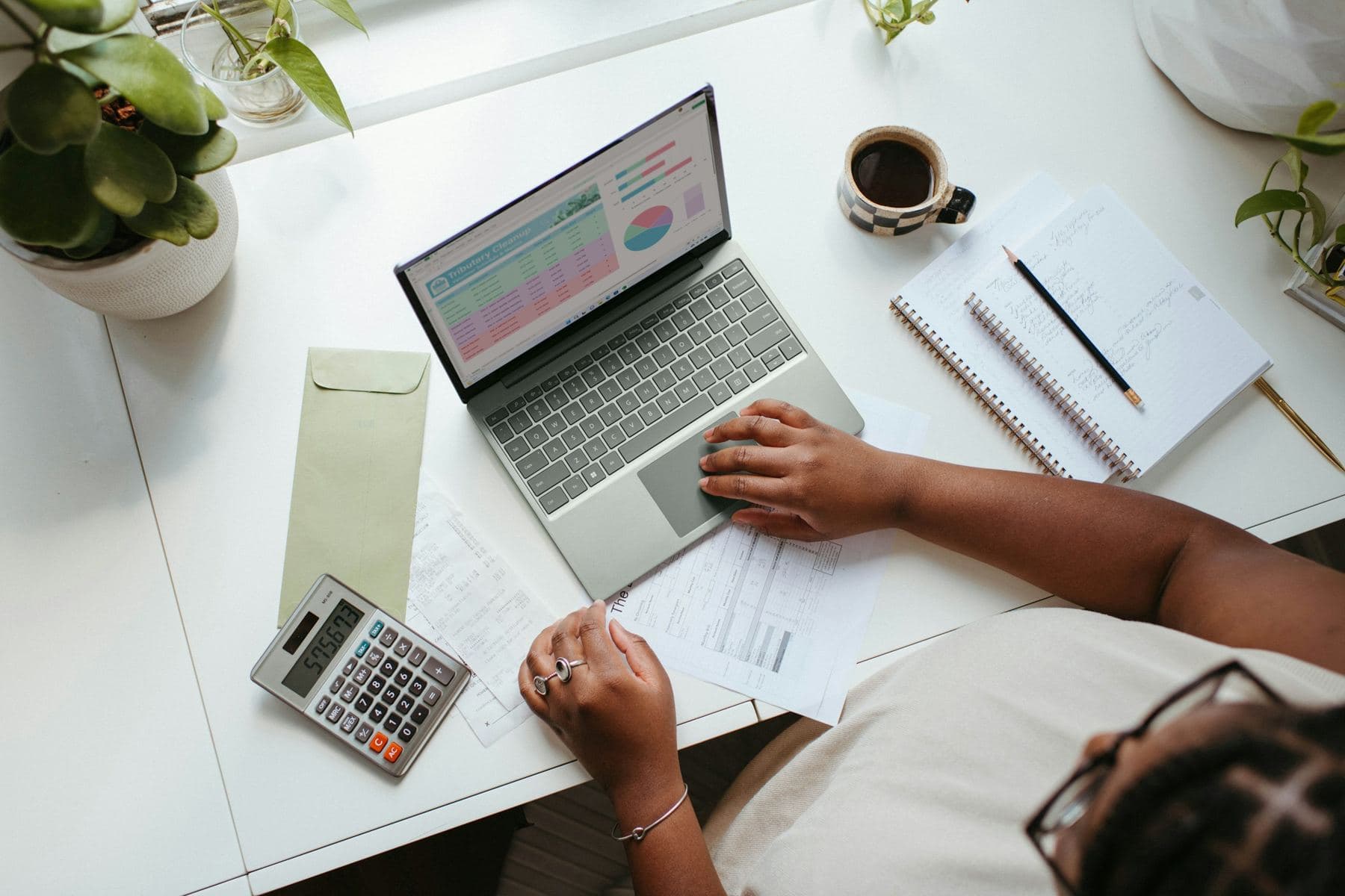 Un tableur, une calculatrice et des documents papier sur un bureau